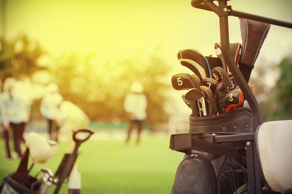 closeup of golf club in bag on golfer background